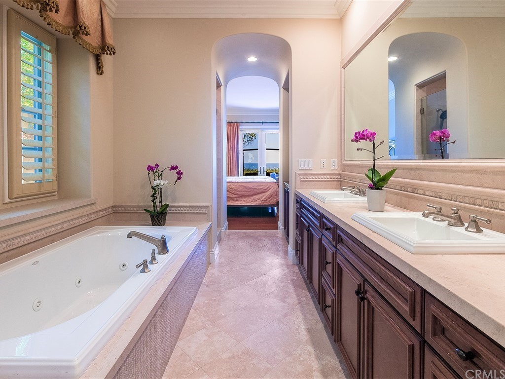 26 Tideline Bluff Newport Coast, CA 92657 - Photo 24 of 31 a spacious bathroom with a granite countertop tub a double vanity sink and a large mirror