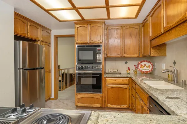 a kitchen with stainless steel appliances granite countertop a refrigerator a stove and sink