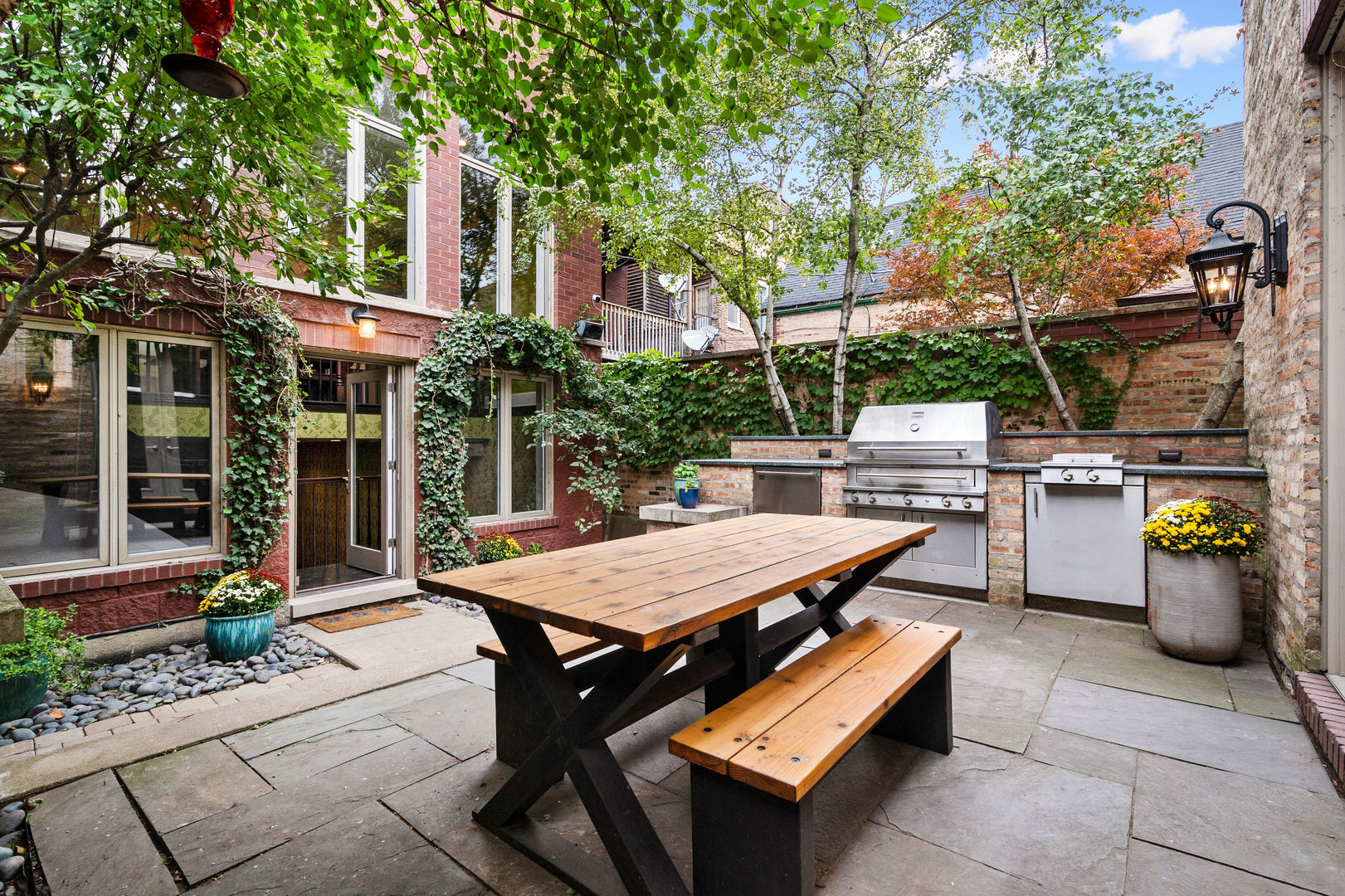 1421 West Lexington Street Chicago, IL 60607 - Photo 46 of 48 a view of a patio with tables and chairs potted plants and a large tree