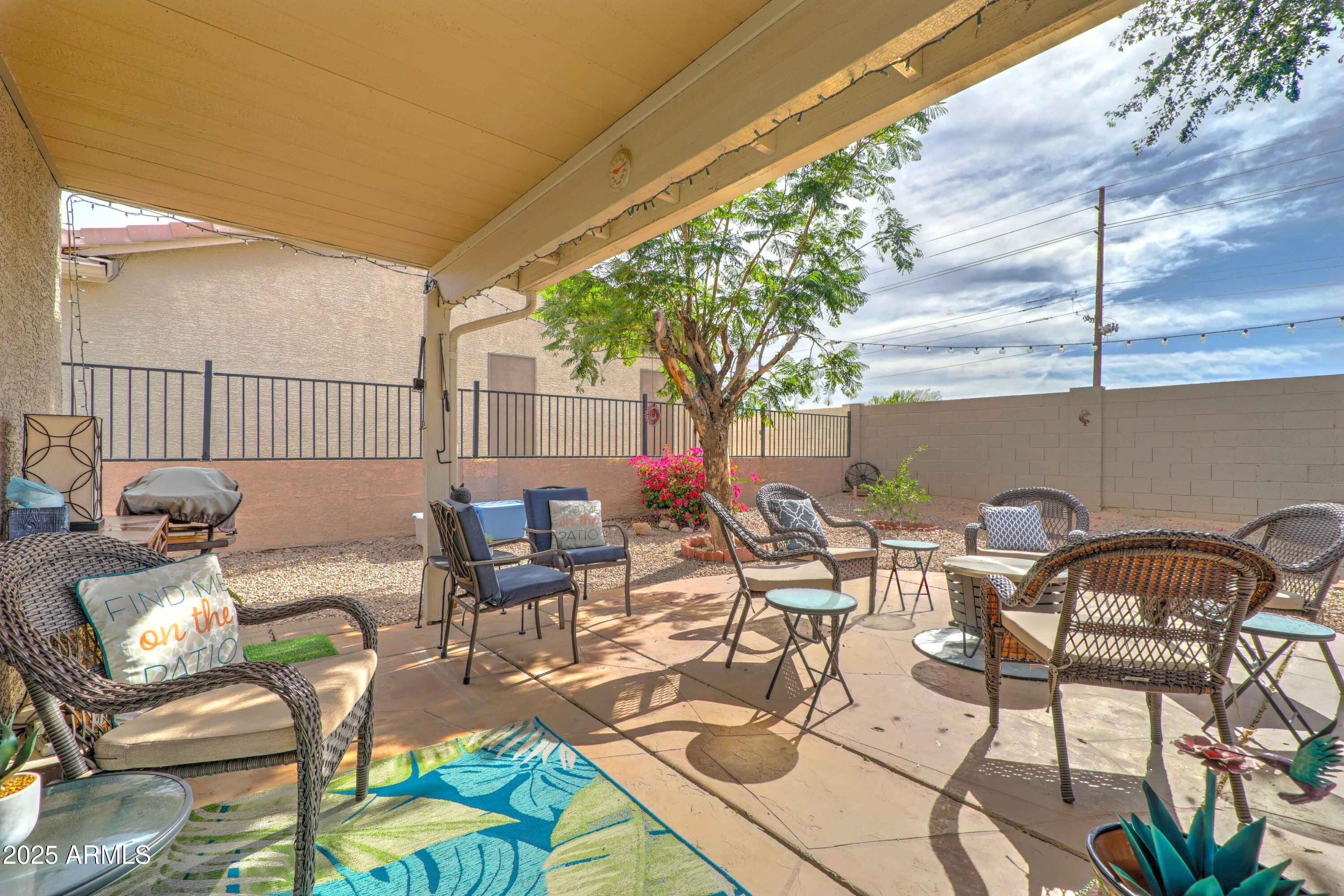 2101 South Meridian Road, Unit 432 Apache Junction, AZ 85120 - Photo 19 of 52 a view of a patio with lawn chairs floor to ceiling window and potted plants
