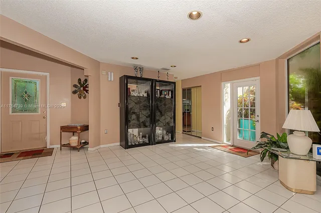 a kitchen with stainless steel appliances granite countertop a stove top oven a sink dishwasher a dining table and chairs with wooden floor