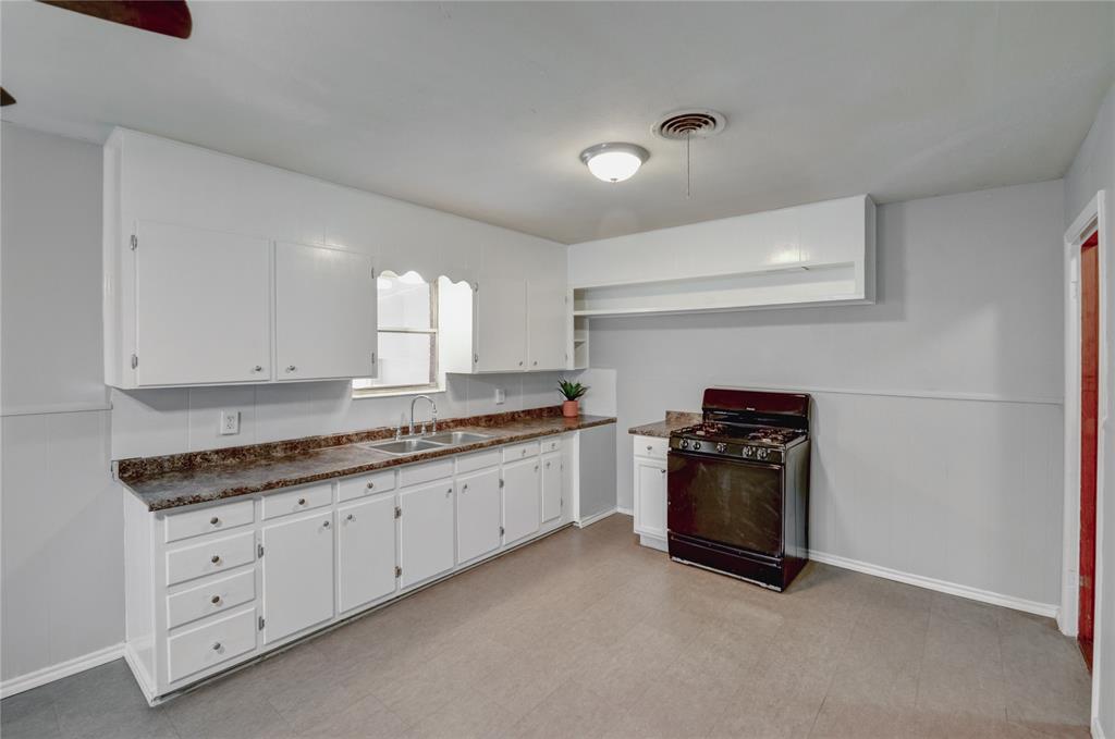 1002 North Stewart Street Azle, TX 76020 - Photo 20 of 29 a kitchen with granite countertop white cabinets and stainless steel appliances