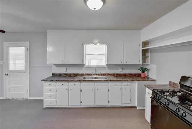 a kitchen with granite countertop white cabinets and stainless steel appliances