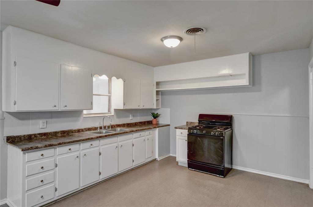 1002 North Stewart Street Azle, TX 76020 - Photo 22 of 29 a kitchen with granite countertop white cabinets and stainless steel appliances