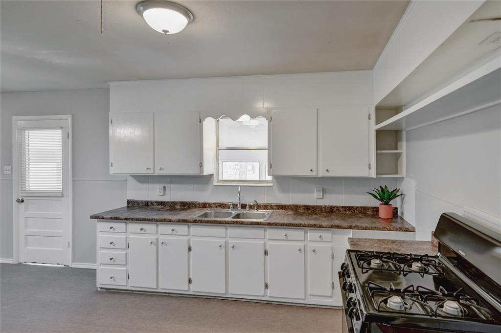 1002 North Stewart Street Azle, TX 76020 - Photo 23 of 29 a kitchen with stainless steel appliances granite countertop a sink stove and cabinets