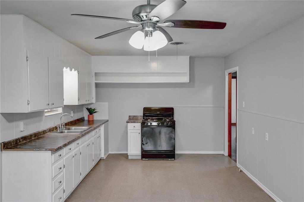 1002 North Stewart Street Azle, TX 76020 - Photo 24 of 29 a kitchen with granite countertop a sink stainless steel appliances and cabinets