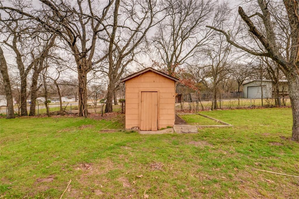 1002 North Stewart Street Azle, TX 76020 - Photo 29 of 29 a white house sitting in middle of forest with large trees