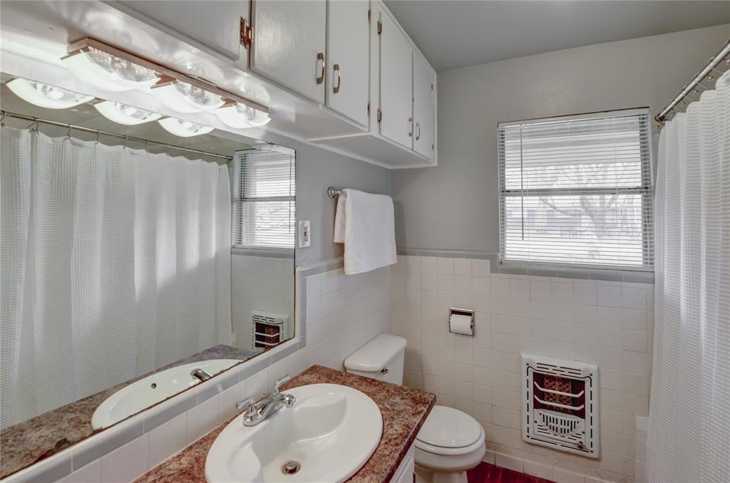 1002 North Stewart Street Azle, TX 76020 - Photo 7 of 29 a bathroom with a sink a toilet and shower