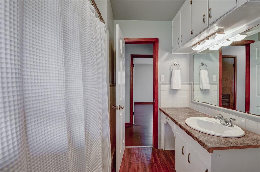 1002 North Stewart Street Azle, TX 76020 - Photo 9 of 29 a bathroom with a granite countertop sink and a mirror