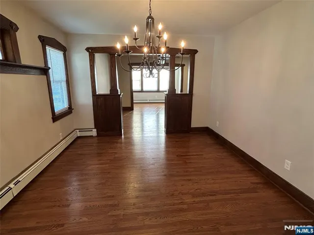 a view of a room with wooden floor and chandelier