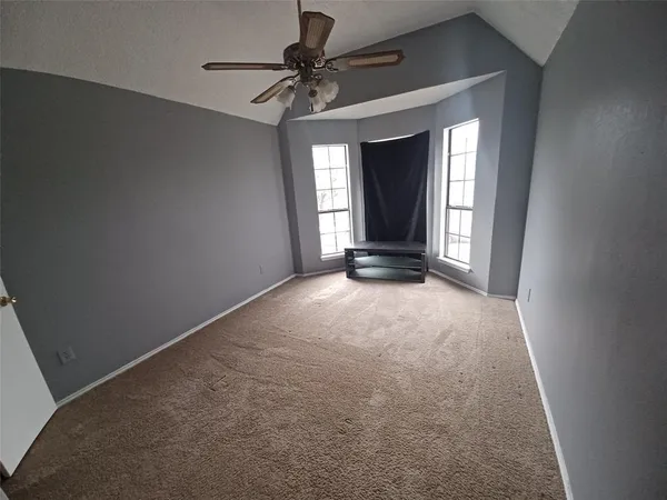 a view of an empty room with a chandelier fan