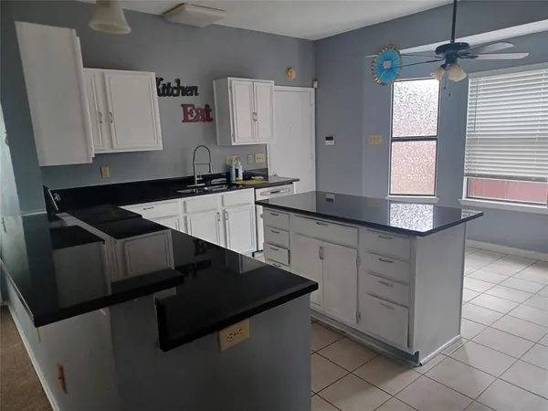 a kitchen with granite countertop cabinets and window