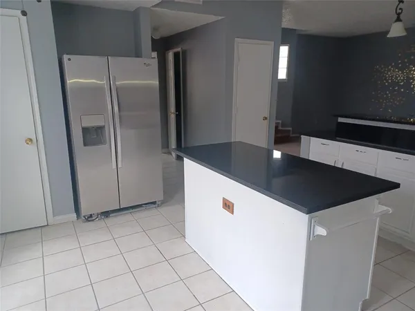 a kitchen with stainless steel appliances a refrigerator a sink a stove and white cabinets