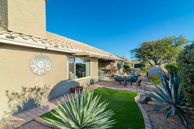 a view of a house with backyard and sitting area