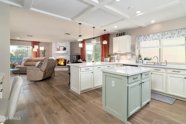 a kitchen with granite countertop a refrigerator a sink dishwasher a stove and white appliances with wooden floor