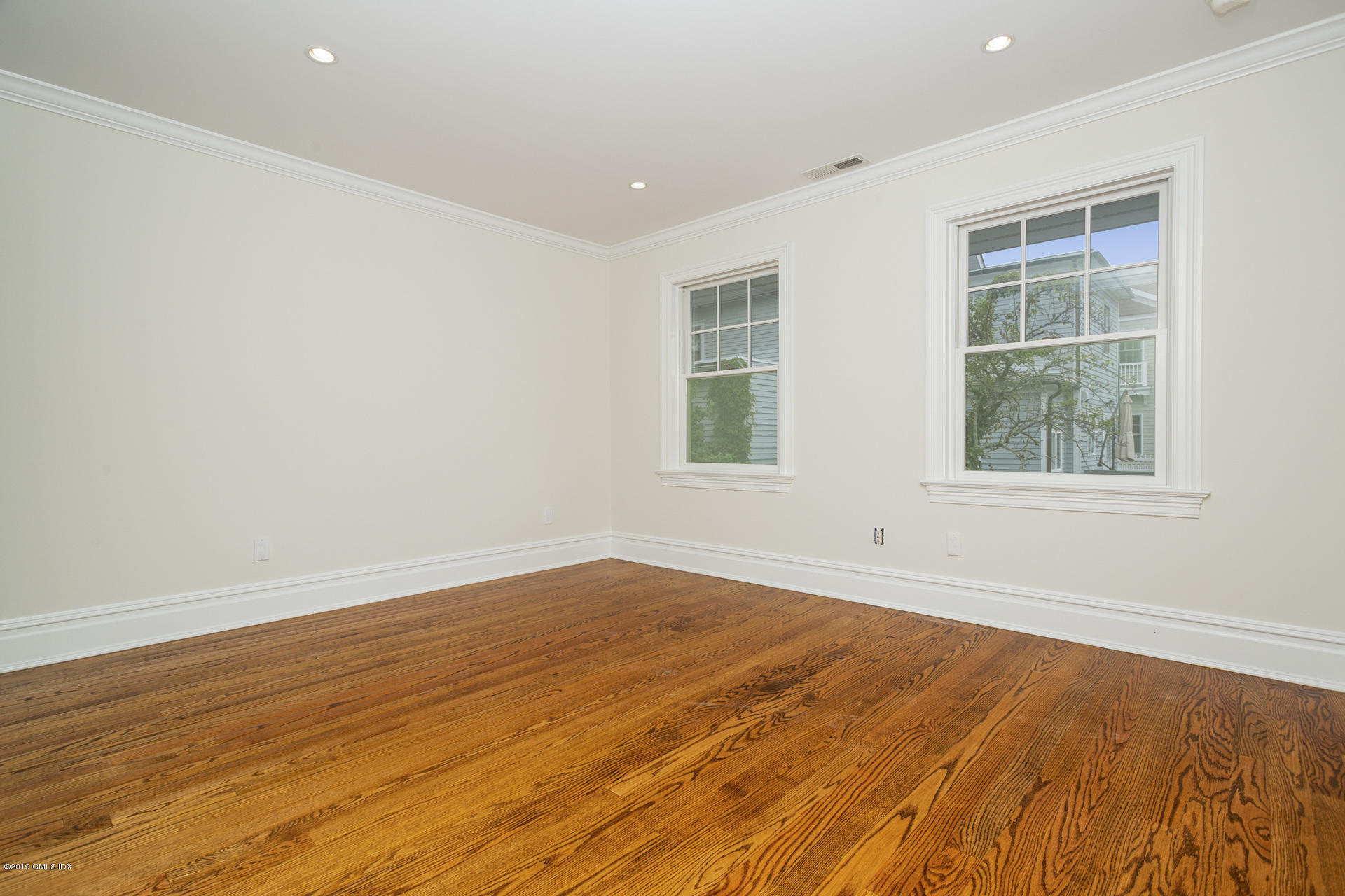 146 East Elm Street, Unit B Greenwich, CT 06830 - Photo 11 of 21 an empty room with wooden floor and windows