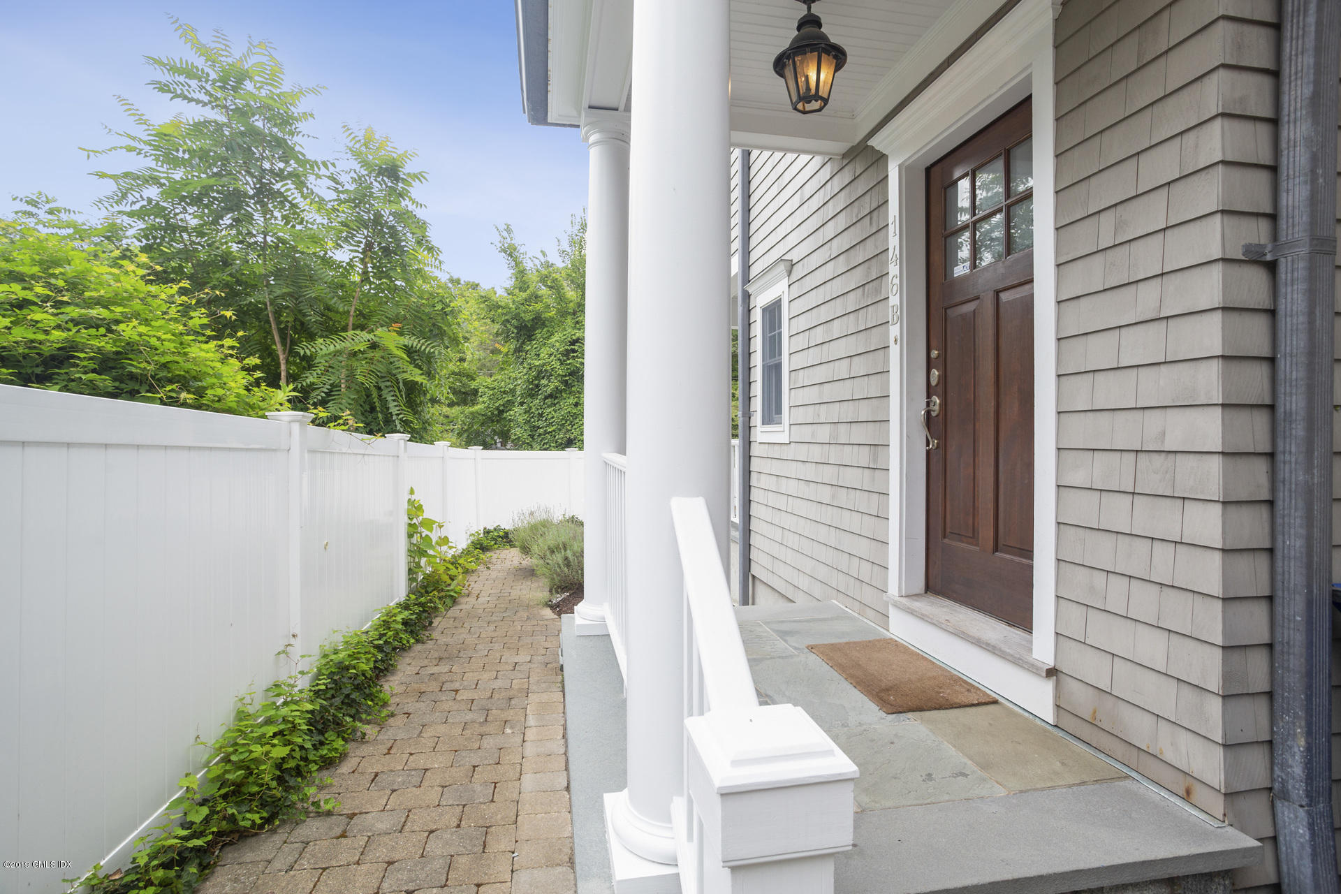 146 East Elm Street, Unit B Greenwich, CT 06830 - Photo 2 of 21 a front view of a house with a yard and potted plants