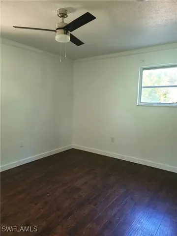 a view of a room with wooden floor cabinets and a ceiling fan
