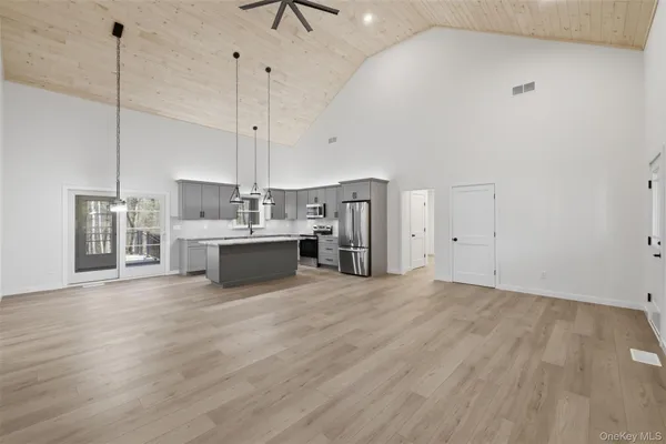 a view of a kitchen with kitchen island a sink wooden floor and a window