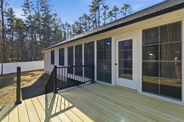 a view of a balcony with wooden floor and iron fence