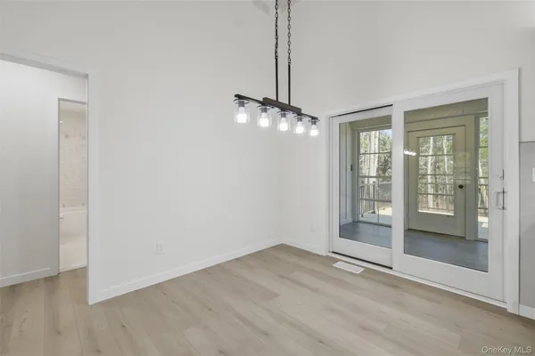 a view of a room with wooden floor and a ceiling fan