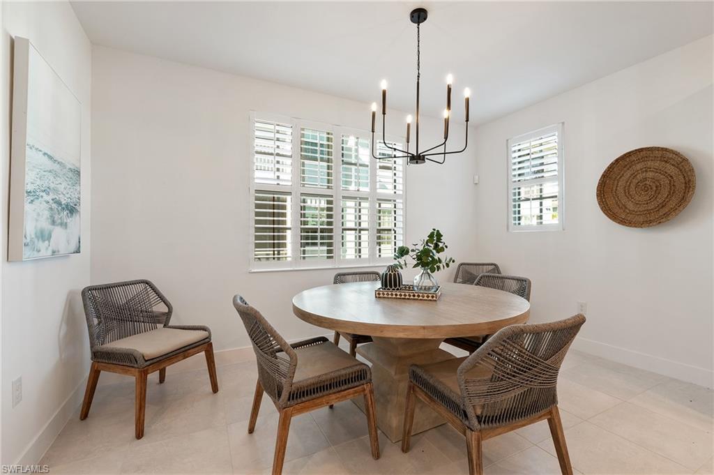 26401 Coco Cay Circle, Unit 101 Bonita Springs, FL 34135 - Photo 12 of 27 a dining room with furniture a chandelier and window