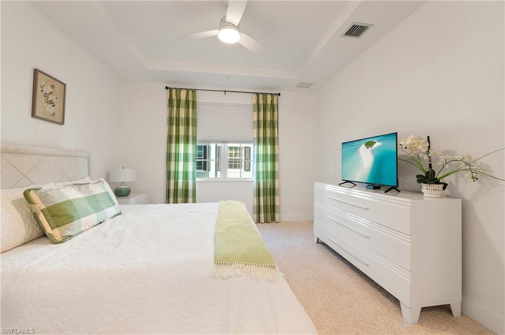 26401 Coco Cay Circle, Unit 101 Bonita Springs, FL 34135 - Photo 14 of 27 a bedroom with a bed and a flat screen tv