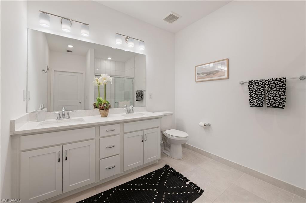 26401 Coco Cay Circle, Unit 101 Bonita Springs, FL 34135 - Photo 15 of 27 a bathroom with a toilet sink and a mirror