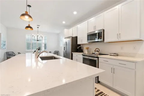 a kitchen with stainless steel appliances a stove a sink a microwave and cabinets