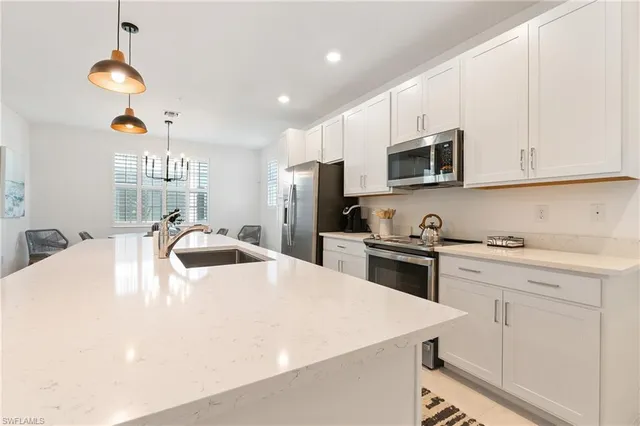 a kitchen with stainless steel appliances a stove a sink a microwave and cabinets