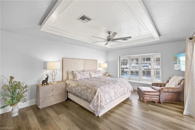 a bedroom with a large bed a flat screen tv and a large window