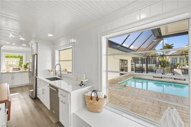 a large white kitchen with a large window