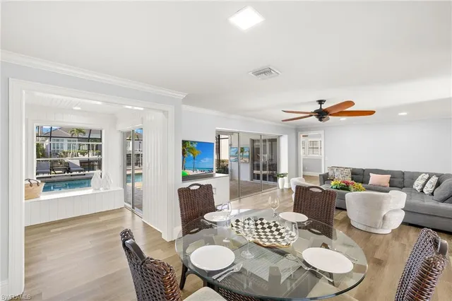 a dining room with furniture a rug and a floor to ceiling window