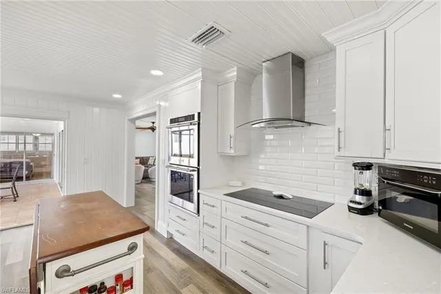 a kitchen with granite countertop a sink stainless steel appliances and cabinets