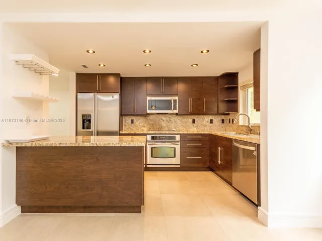 a kitchen with stainless steel appliances a stove a sink and a microwave