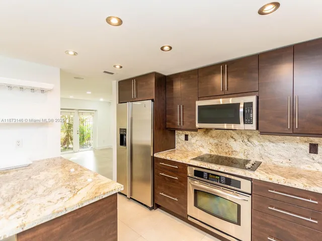 a kitchen with stainless steel appliances granite countertop a stove and a refrigerator