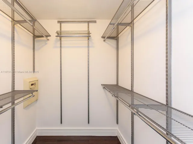 a view of walk in closet with empty racks