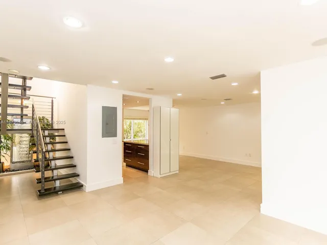 an empty room with windows and stairs