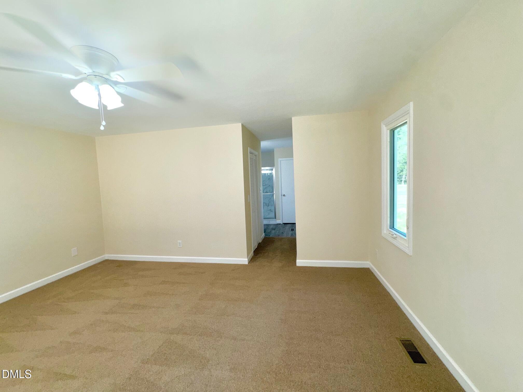 1720 Ross Mill Road Henderson, NC 27537 - Photo 22 of 42 an empty room with chandelier fan and windows