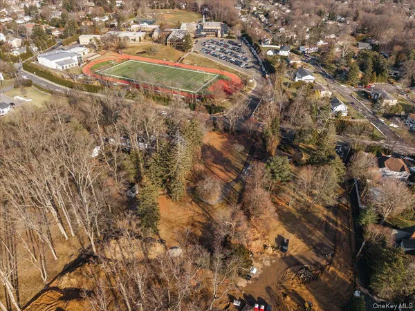 an aerial view of residential houses with outdoor space and trees