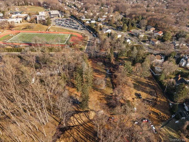 an aerial view of residential houses with outdoor space and trees