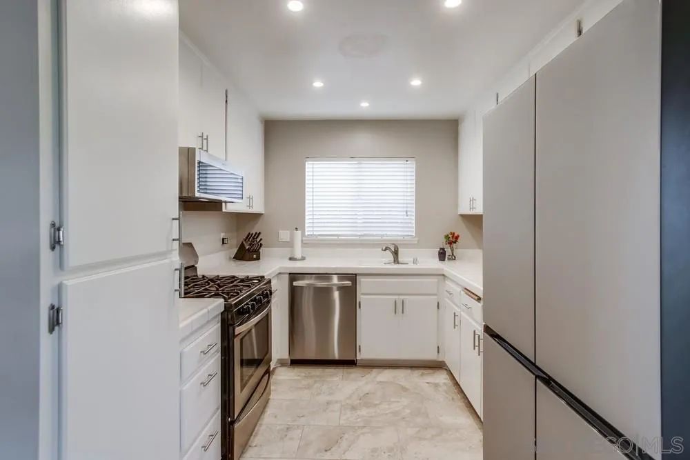 898 Friendly Circle El Cajon, CA 92021 - Photo 13 of 38 a kitchen with white cabinets and appliances