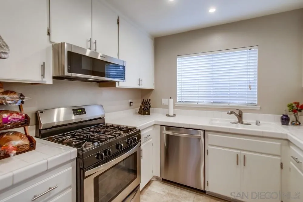 898 Friendly Circle El Cajon, CA 92021 - Photo 15 of 38 a kitchen with stainless steel appliances a sink a stove and microwave