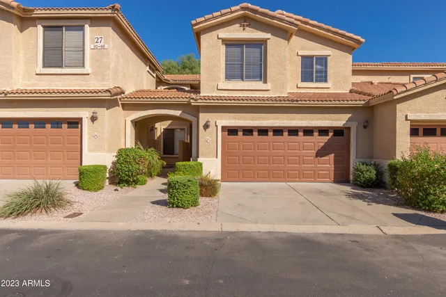 a front view of a house with a yard and a garage