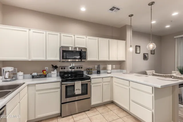 a kitchen with white cabinets appliances and a sink