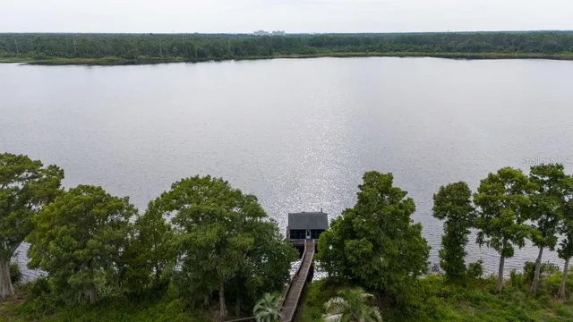 an aerial view of a house with garden space and lake view in back