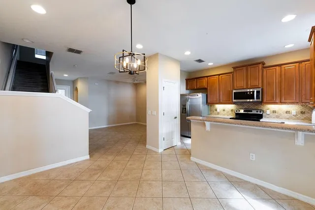 a kitchen with stainless steel appliances granite countertop a refrigerator a oven a sink a microwave and a refrigerator