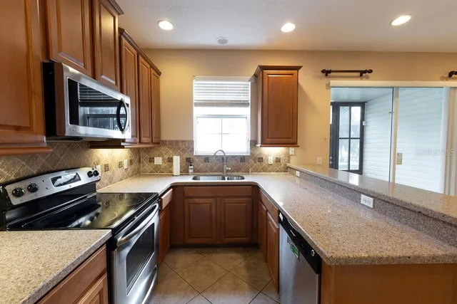 a kitchen with stainless steel appliances granite countertop a sink stove and refrigerator