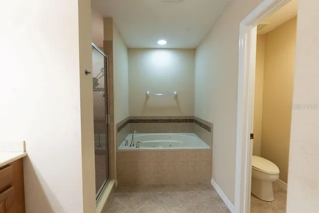 a bathroom with a tub shower and toilet