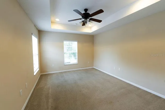 an empty room with a window and a ceiling fan